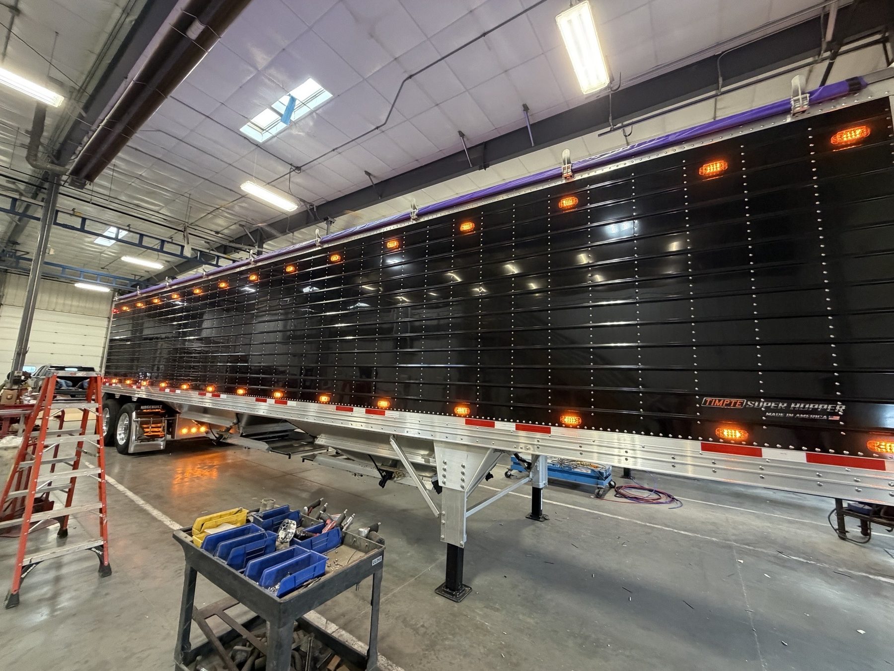 DQS hopper trailer with marker lights on inside a shop