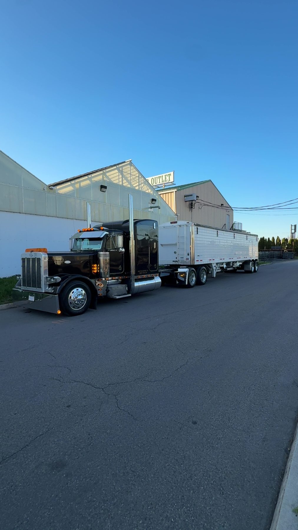 DQS Transport black Peterbilt and white hopper trailer